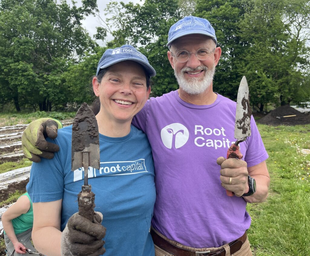 two people smiling and holding up trowels