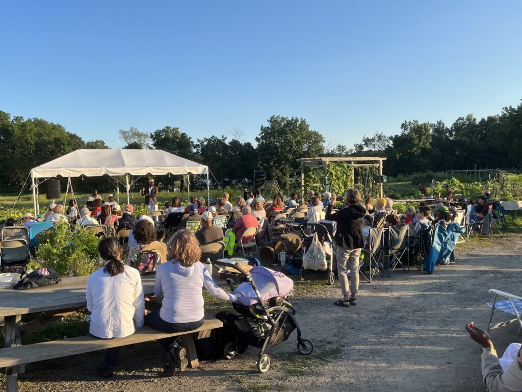 a crowd of people outside watching an event under a canopy